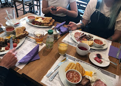 A table laid with a full brunch — eggs, bacon, beans, juice and tea
