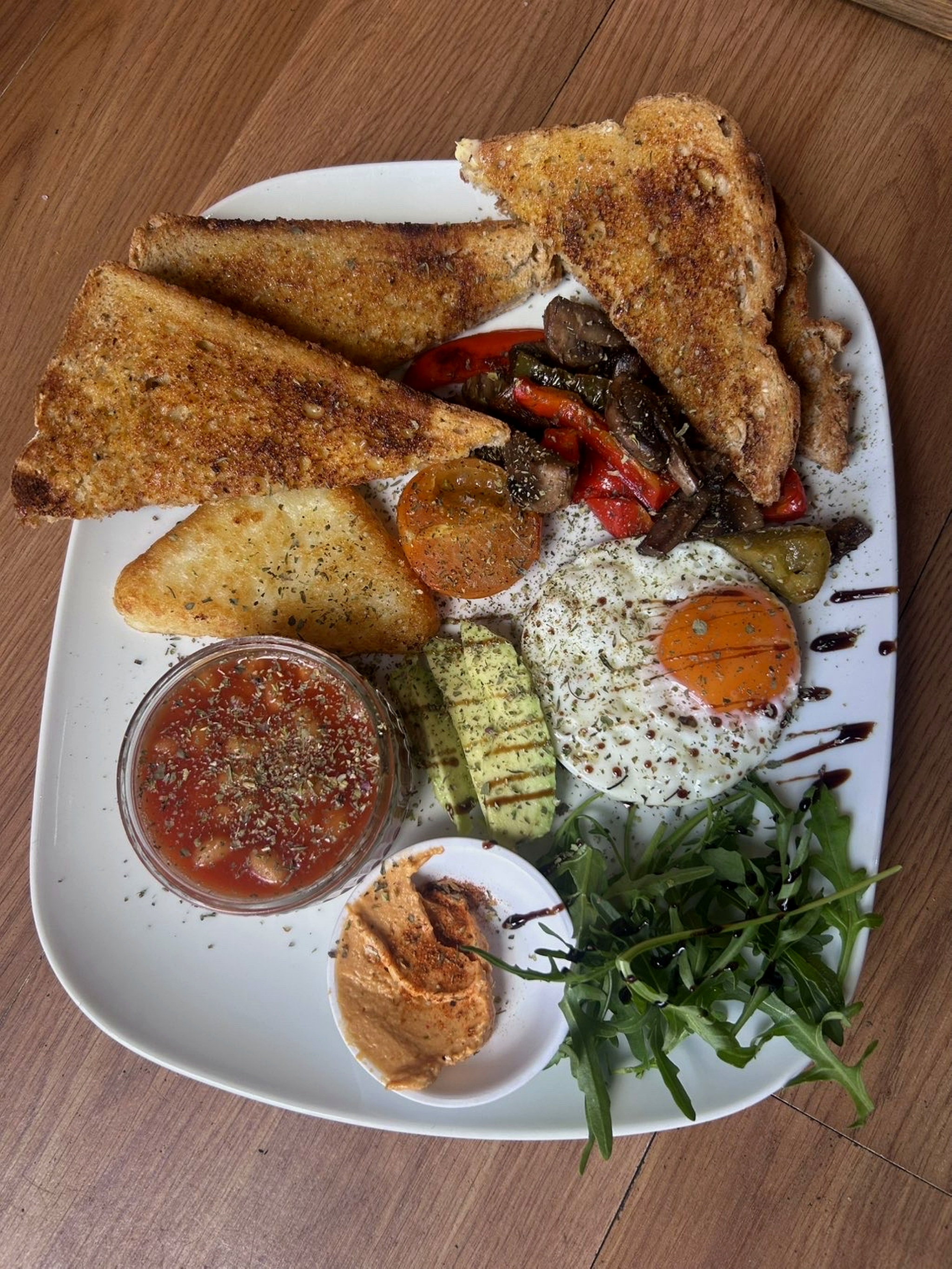 Cafe V76 vegetarian breakfast with toast, hash brown, avocado, egg, rocket and grilled vegetables